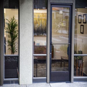 Image of the front door of Los Gatos psychologist Ginny Estupinian, PhD, ABPP. The door features the practice's logo prominently displayed, with clear signage indicating first-floor access, set against a professional and welcoming exterior