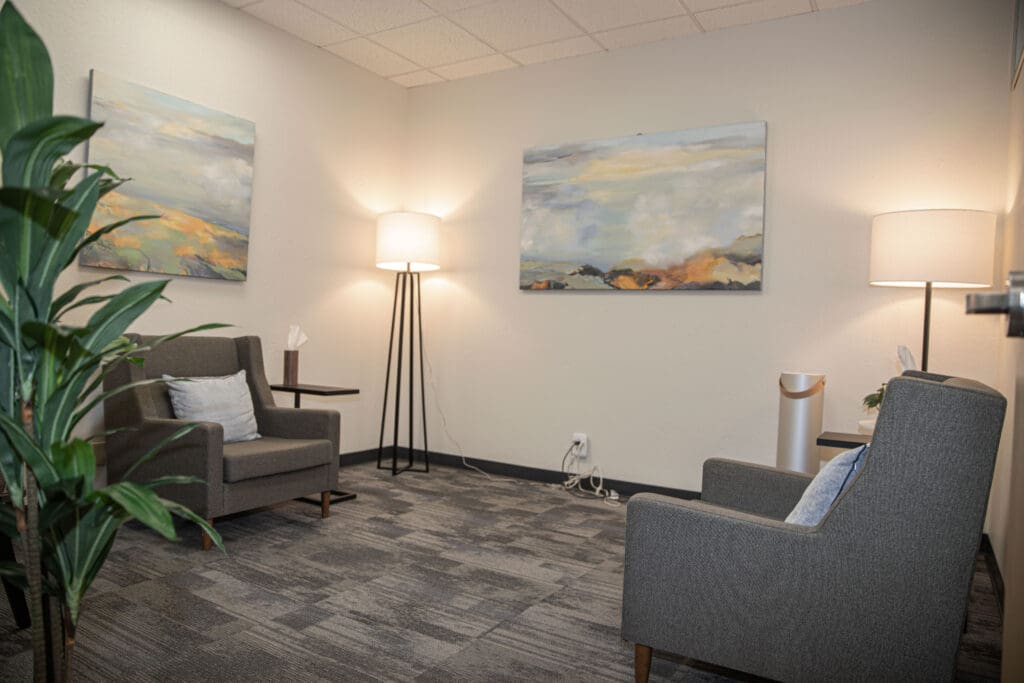 Photo or illustration of a cozy and welcoming therapy office interior at the Los Gatos office of psychologist Ginny Estupinian, PhD. The setting includes comfortable armchairs, soft lighting, beautiful art and calming decor, creating a safe and relaxing environment for clients