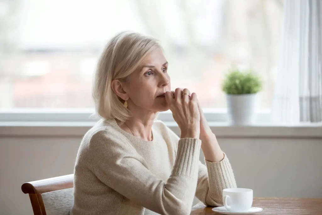 Photo of a middle age woman pondering going through a Gray Divorce. Ginny Estupinian PhD helps people through Gray Divorce.