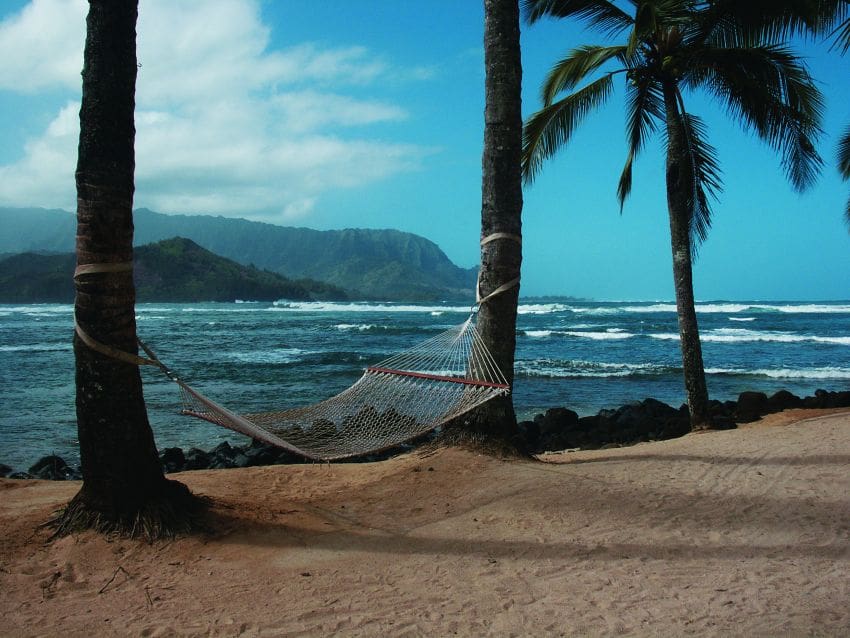 Empty hammock by tropical bay symbolizing restorative vacation as taught by Ginny Estupinian PhD Los Gatos psychologist