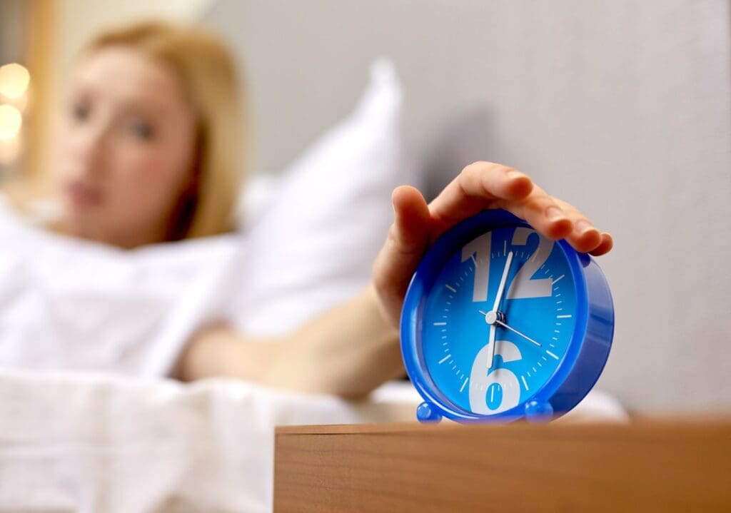 Photo of woman waking up due to daylight savings