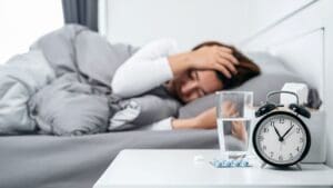 Photo of a professional woman lying awake due to insomnia, illustrating how Dr. Ginny Estupinian, PhD, helps individuals overcome sleep difficulties through evidence-based therapy